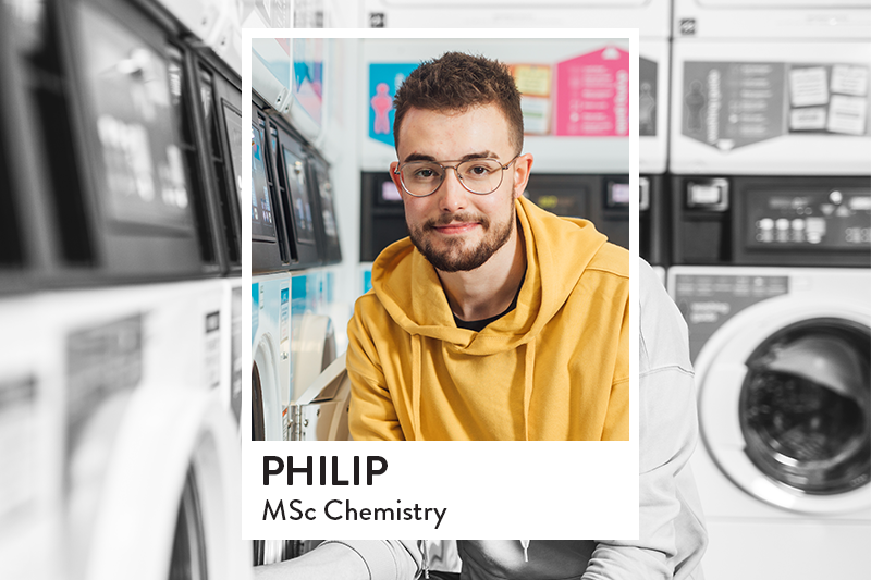 Image of student in Elms laundry room using the washing machine