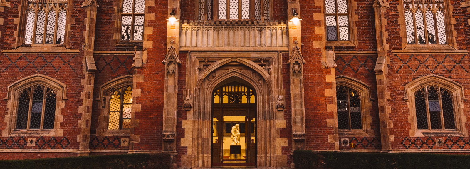 Close-up of Lanyon Building façade and entrance showing lit statue of Galileo through the front door
