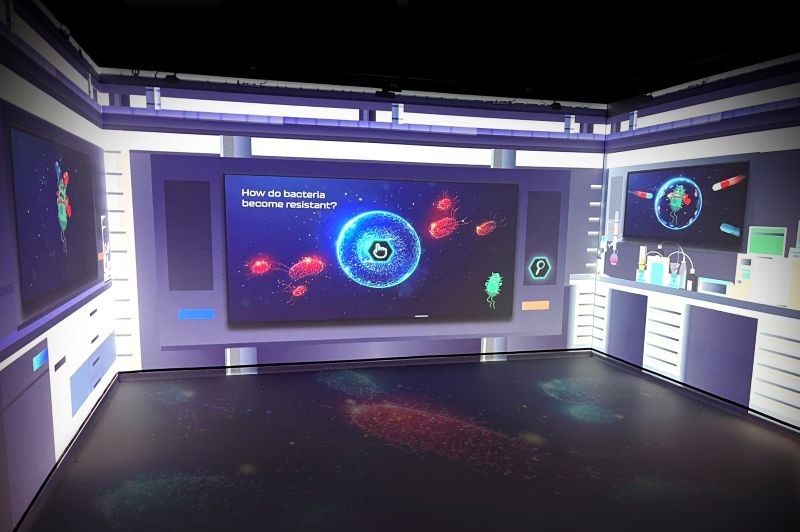antimicrobial resistance graphics being shown on large surrounding screens in the immersive experience space in W5, Belfast