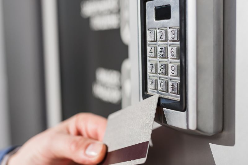 close up of person holding access card up to a building access control pad