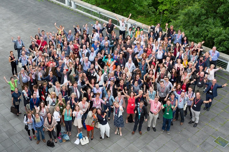 aerial shot of group of smiling and waving EALTA conference attendees