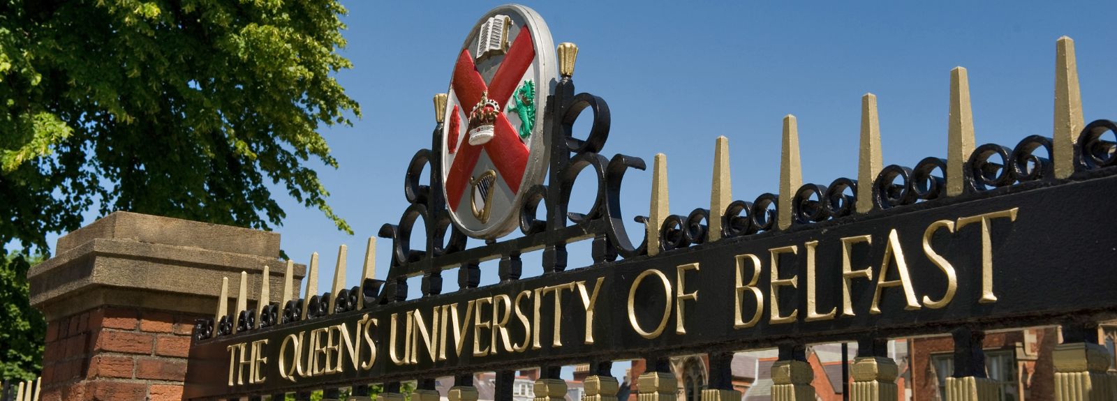 close-up of gates of Queen's University Belfast showing the wording The Queen's University of Belfast and university crest