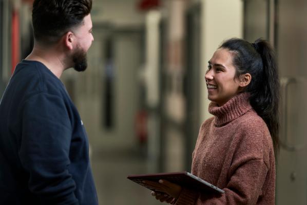 Female talking to male while holding iPad tablet